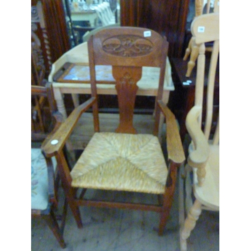 102 - An oak Arts and Crafts armchair with rush seat