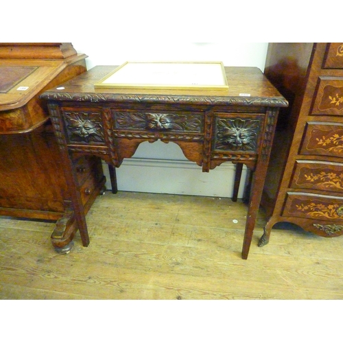 188 - An oak desk with carved detail and cats heads to the drawers