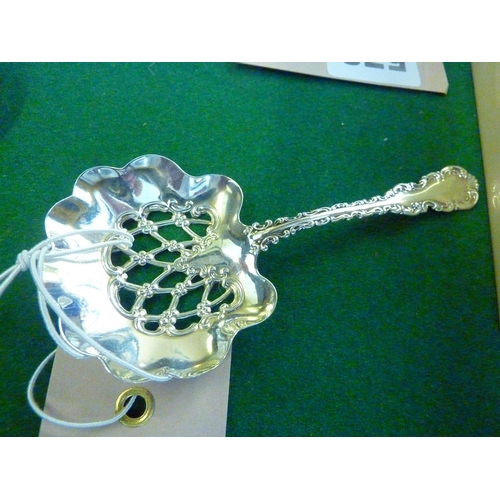 568 - A decorative sterling silver filigree strainer spoon