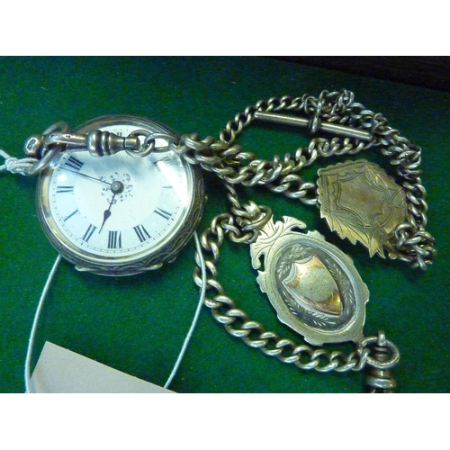 590 - A decorated silver pocket watch with a watch chain and 2 fobs