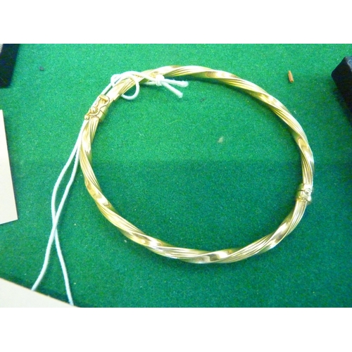 597 - A 9ct gold bangle of twisted design
