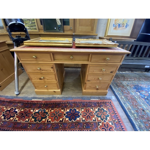 14 - A pine kneehole desk with leather inlay to the top and brass knobs