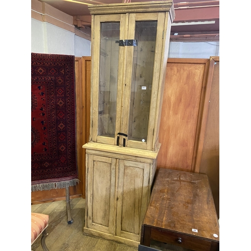 26a - A narrow pine display cabinet over double cupboard base