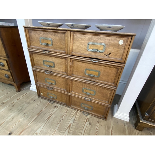 41 - A bank of 8 oak drawers with hinged flap fronts and metal work handles stamped 