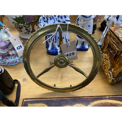 425 - A brass wheel with an anchor hinged support