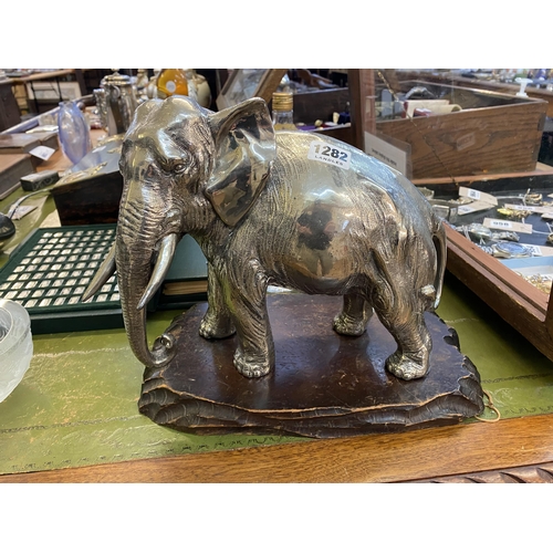 1282 - An Indian pewter model of an elephant with good proportions and on a wooden base, 22cm tall