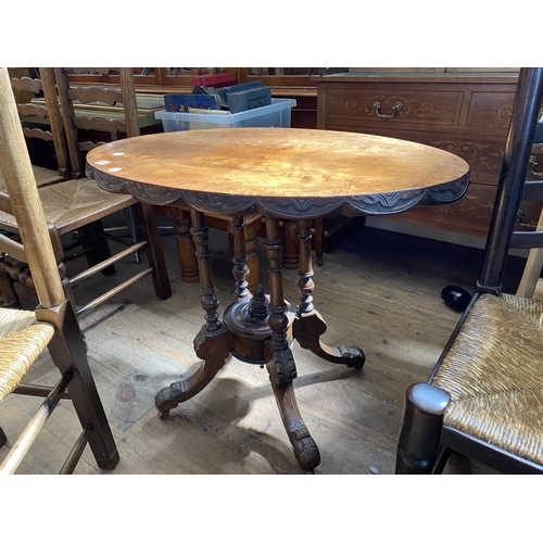 123 - A Victorian walnut occasional table with shaped detail around the top and an ornate pedestal base