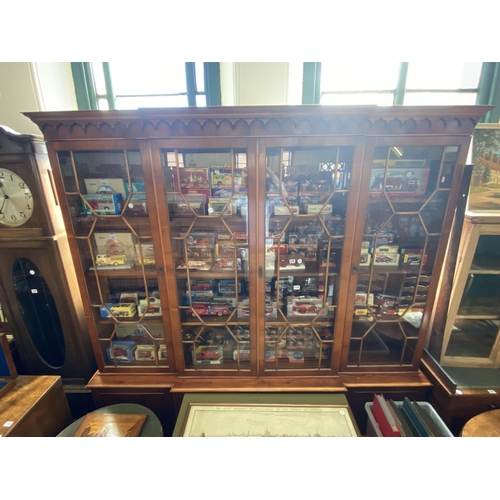 129 - A large yew wood veneered dresser with glazed doors to shelved compartments above cupboards to the b... 