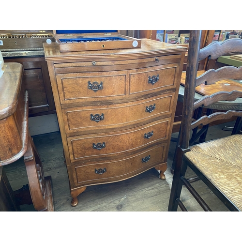 133 - A reproduction walnut veneered serpentine fronted chest of drawers with brushing slide