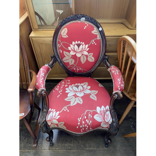 152a - A Victorian mahogany hoop backed upholstered armchair with scrolled arms and carved detail