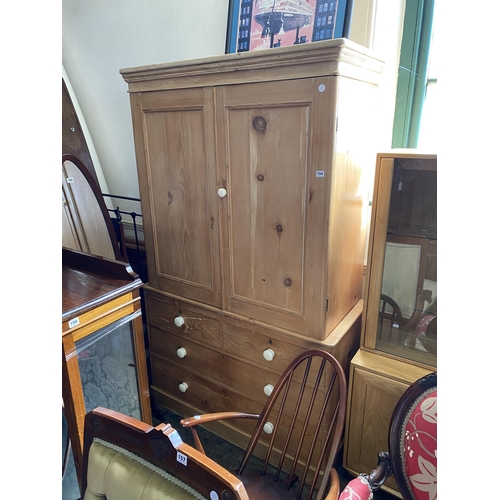 154 - A pine double cupboard over drawers with panelled doors and porcelain knobs