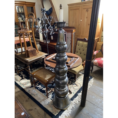 160 - A tall metal work standard lamp of cylindrical form with oriental decorative detail