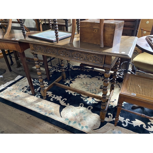 163 - An oak side table with carved detail to the drawer, bobbin turned legs