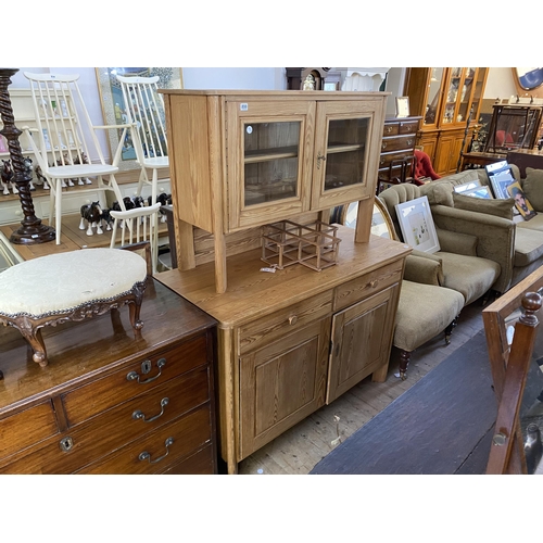 233 - A heavy pine dresser with panelled doors, 2 drawers and a glazed cabinet top section with canted sup... 