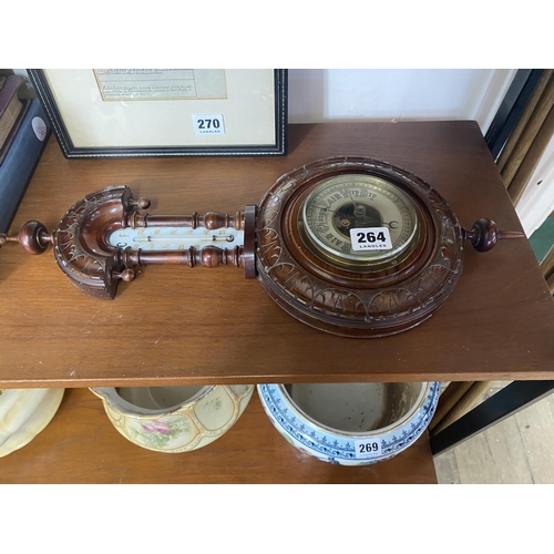 264 - A decorative walnut cased barometer with carved detail arched pediment and finials with retailers st... 