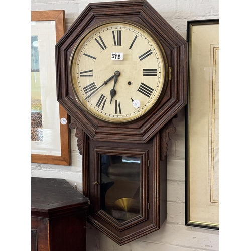 39b - An octagonal oak cased wall clock with a painted dial and Roman numerals, glass door to the pendulum