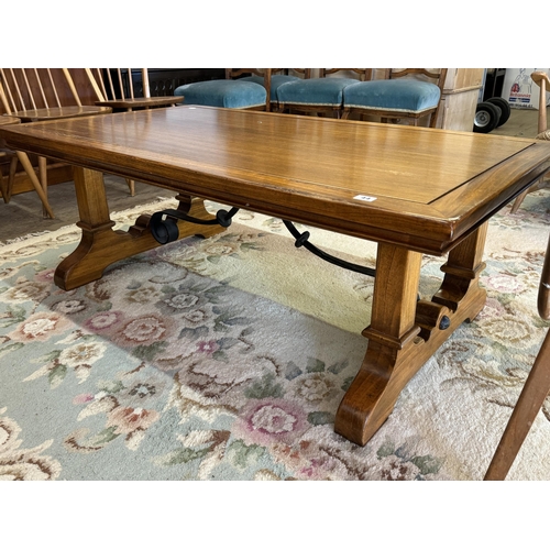 44 - A heavy coffee table with shaped stretchers and scrolled metalwork detail