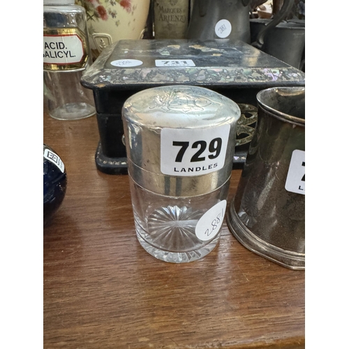 729 - A glass jar with a silver lid