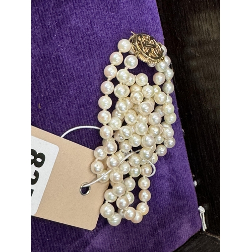 835 - A cultured pearl necklace with a decorative 9ct gold clasp