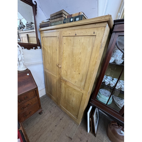 95 - A pine storage cupboard with a shelved interior