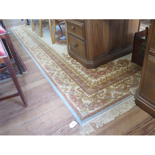 104 - A French style carpet, the pink and gold floral scroll design on a cream field and similar border, 3... 