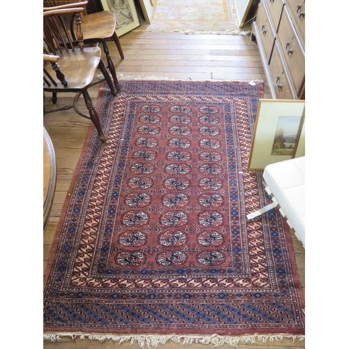 106 - A Bokhara rug, the three rows of eleven guls on a brown field within a multiple border, 192 x 128 cm