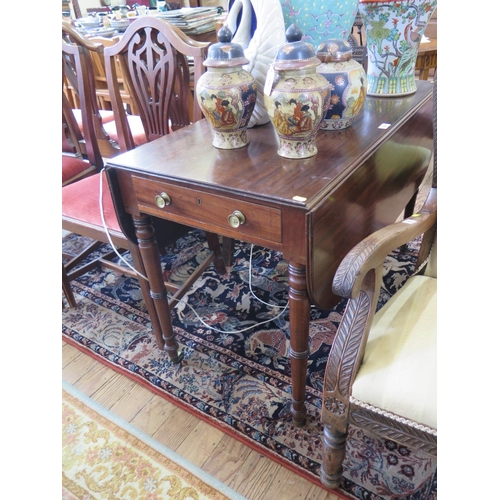 69 - A Regency mahogany Pembroke table, with frieze drawer on ring turned tapering legs and brass castors... 