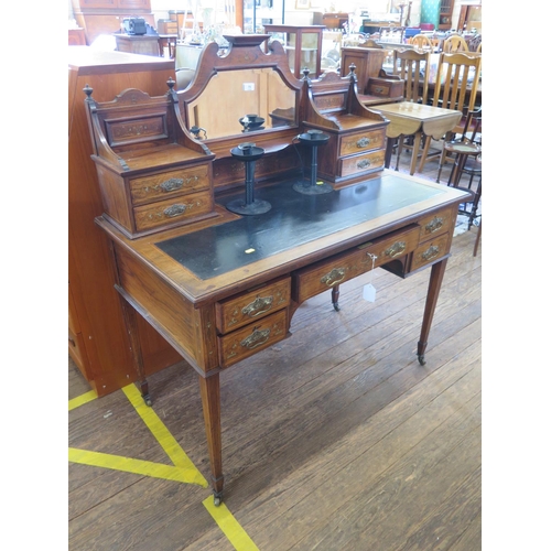 73 - An Edwardian inlaid rosewood writing desk, the raised mirrored back with trinket drawers, over a lea... 