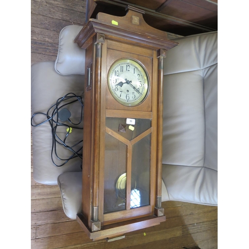 93 - A 1930s wall clock, with silvered dial and glazed door enclosing a three train movement striking on ... 