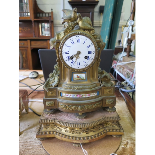 94 - A French gilt metal and porcelain mounted mantel clock, deipicting musical instruments, armour and t... 