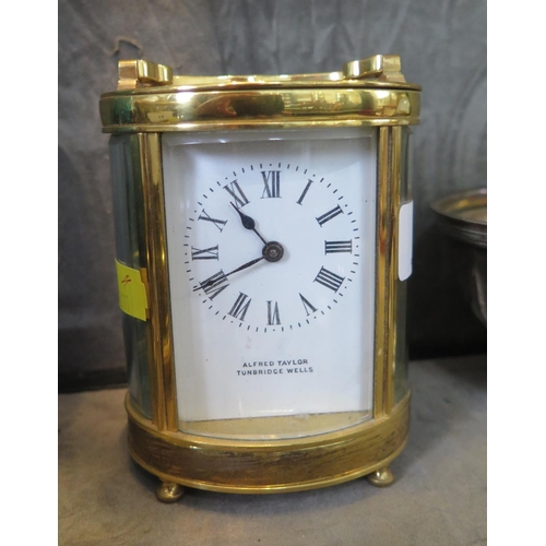 99 - An oval brass carriage timepiece clock, inscribed Alfred Taylor Tunbridge Wells, with enamelled dial... 