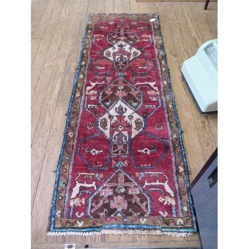 80 - A Persian thick pile runner, with ivory and brown medallions on a red ground, 195 x 70 cm