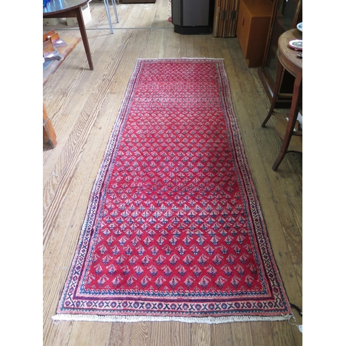 82 - A Persian Sarouk Mir design runner, with allover boteh design on a red ground, 300 x 109 cm