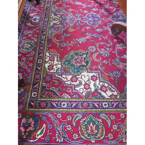 84 - A Persian Tabriz carpet, the blue and ivory medallion on a red ground filled with foliate designs an... 