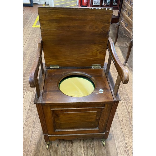 46 - A Victorian Pine Commode. The hinged lid opening to reveal handles. Twin side grips and with a potty... 
