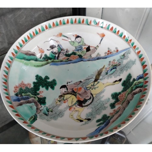 401 - A Chinese porcelain famille-verte bowl decorated with equestrian warriors 26cm diameter. (glue repai... 