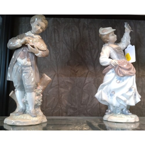 393 - Vintage 1970's LLadro pair of figurines; boy with flowers 4757 and girl with a bird in her hand 4758