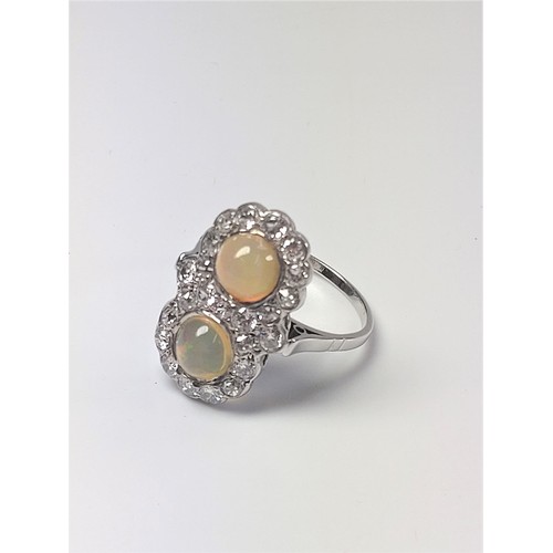 1061 - An unusual 18ct white gold Victorian ring set with two cabochan opals and several old European-cut d... 