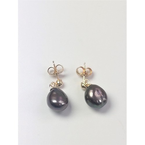 1065 - A pair of yellow gold naturally-formed black pearl drop studs with tones of mauve and green.