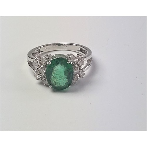 1072 - An 18ct white gold oval emerald and marquise diamond ornate cluster ring. Emerald 2.52ct. Diamonds 0... 