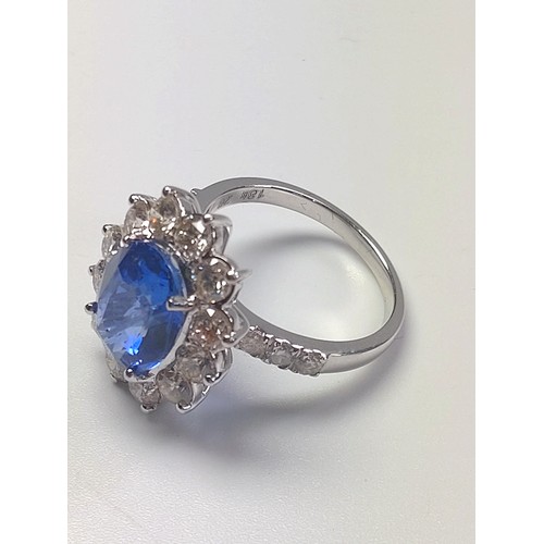 1073 - An 18ct white gold large oval sapphire and Round Brilliant Cut diamond cluster ring and shoulders, b... 