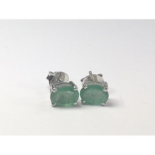 1078 - A pair of emerald studs in silver