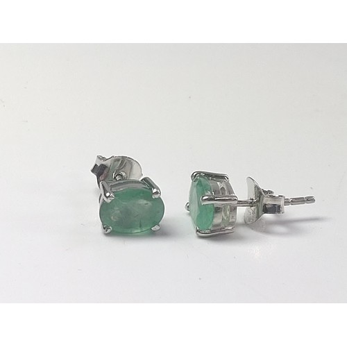 1078 - A pair of emerald studs in silver