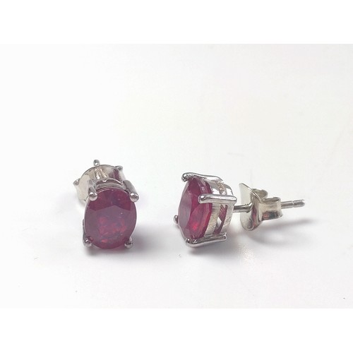 1079 - A pair of treated ruby studs in silver.