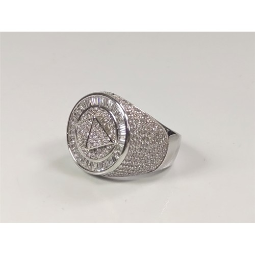 1054 - A large silver dinner ring set with several white round cubic zirconia. Size Q.