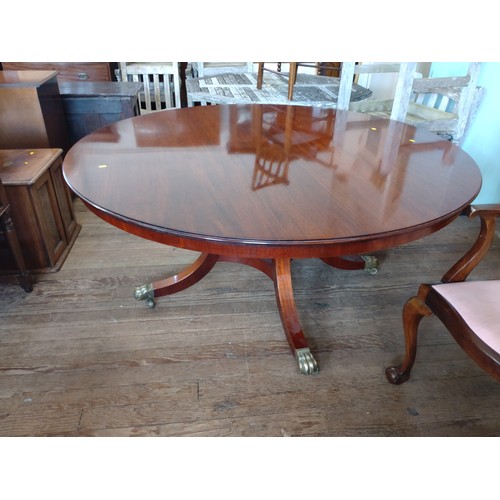 60 - A circular dining table on claw feet and casters. 73cm x 158cm x 158cm.