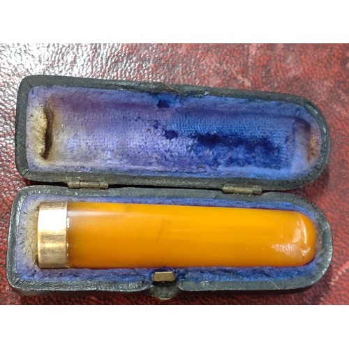 114 - A cased 9ct gold/ amber cheroot holder