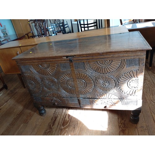 76 - A 17th century later carved oak chest on feet. 81cm x 124cm x 60cm.