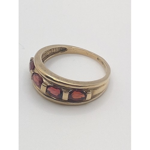 426 - A 9ct yellow gold and garnet set dress ring, stamped 375 to shank,  size 0 1/2. 2.8 grams.