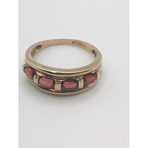 426 - A 9ct yellow gold and garnet set dress ring, stamped 375 to shank,  size 0 1/2. 2.8 grams.